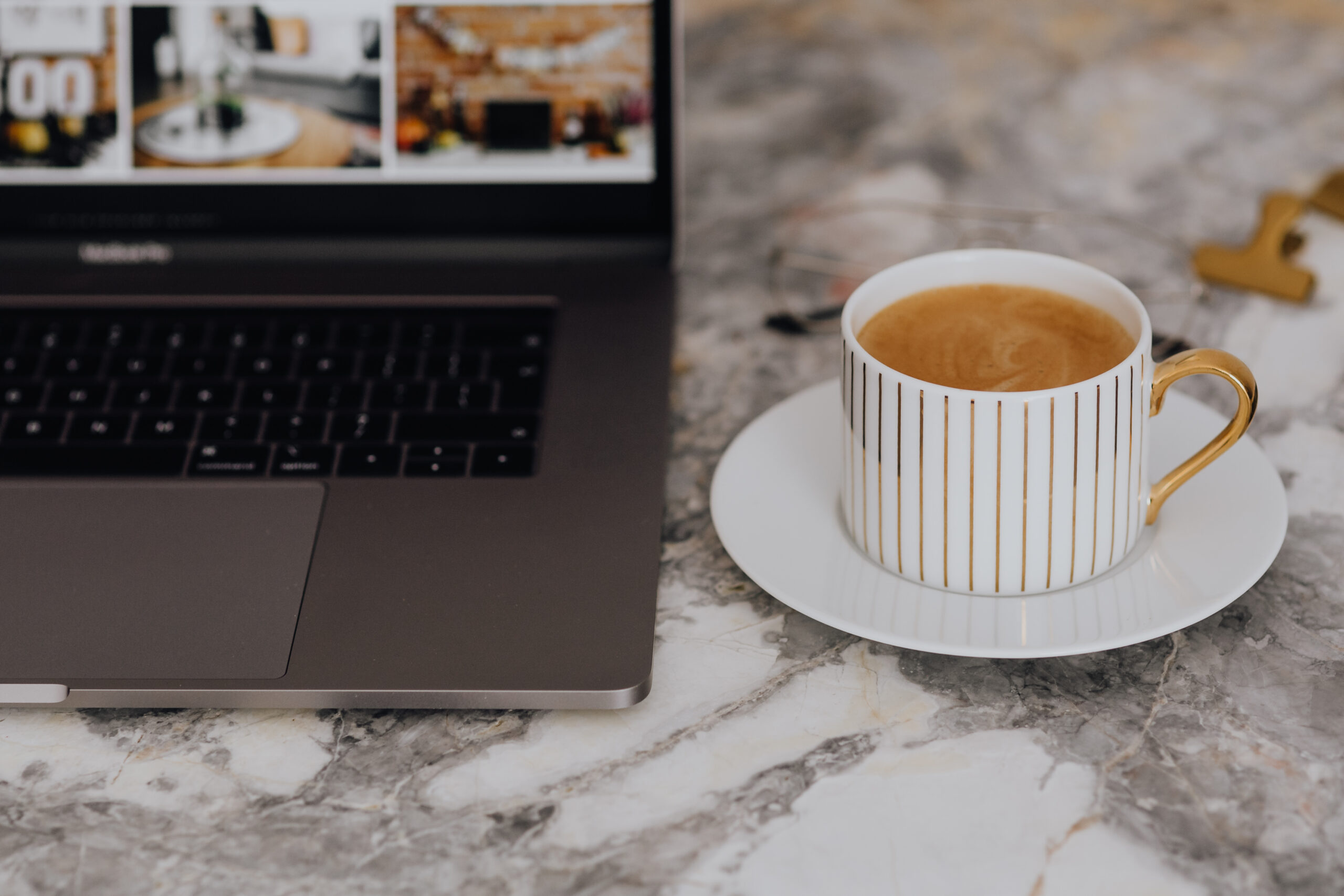 Laptop with Google Sheet Systems and a coffee on a marble table